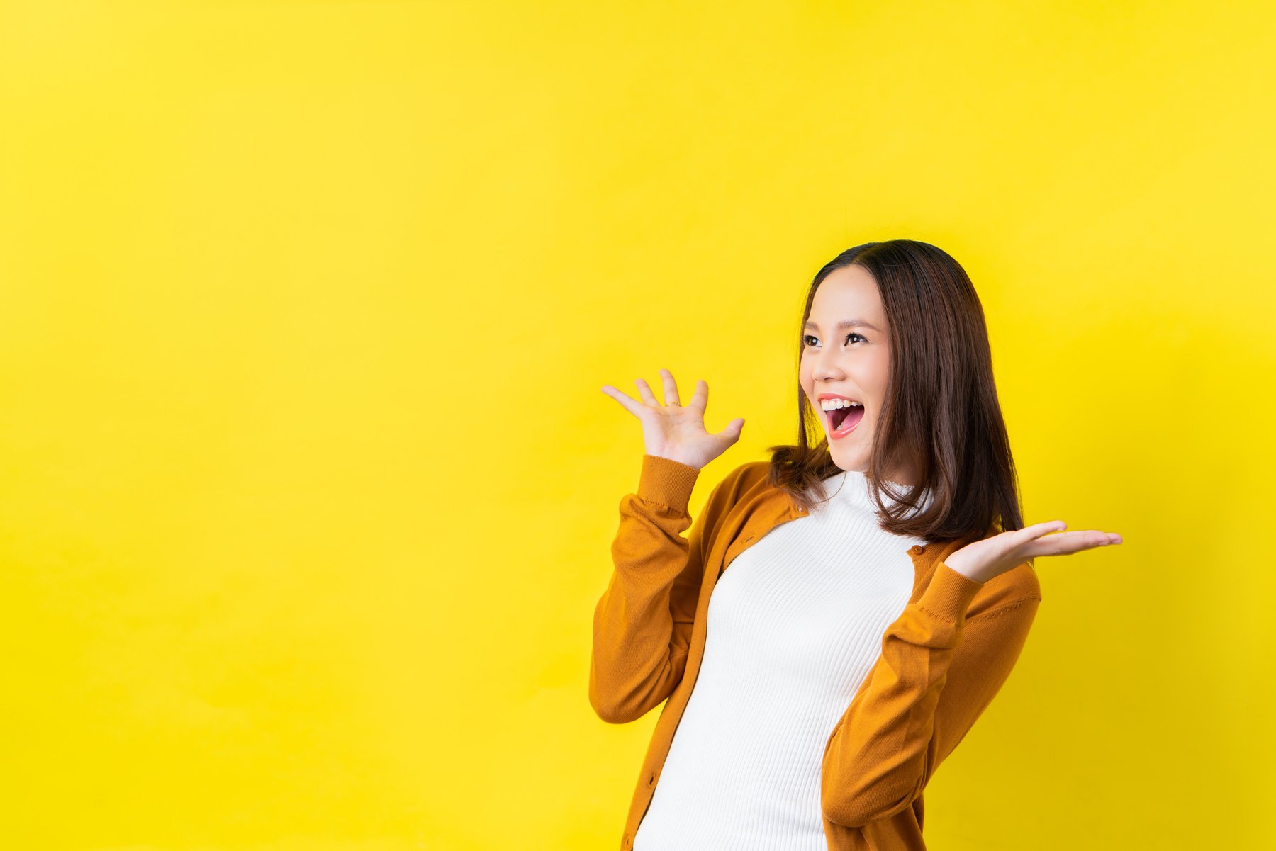 Asian girl is surprised she is excited.Yellow background studio