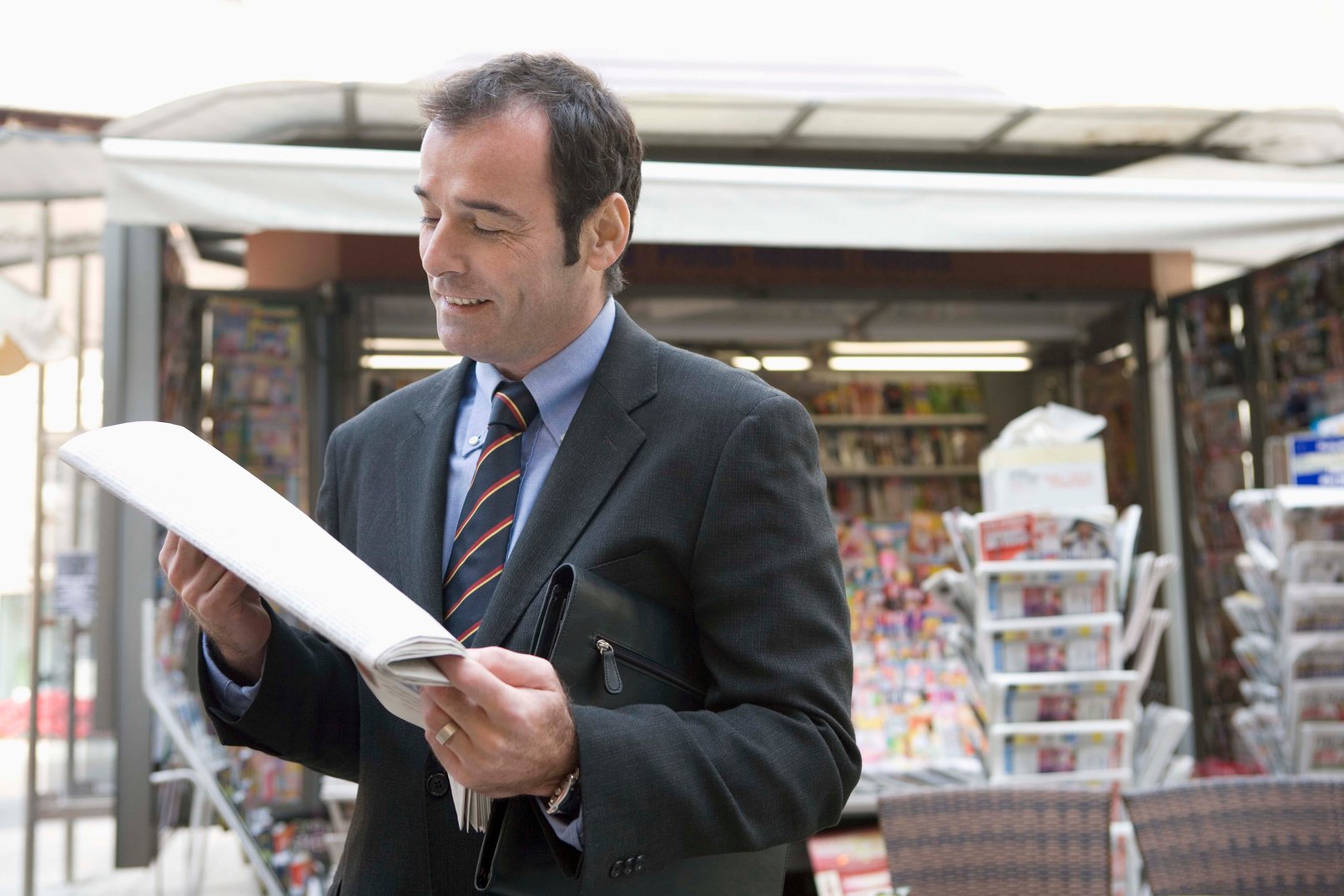 Businessman Reading Newspaper Outdoors