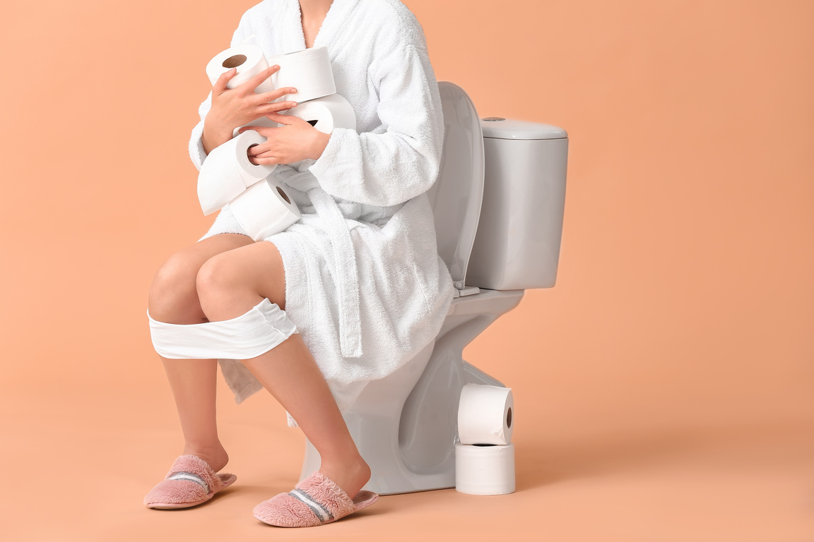 Woman with Many Rolls of Paper Sitting on Toilet Bowl