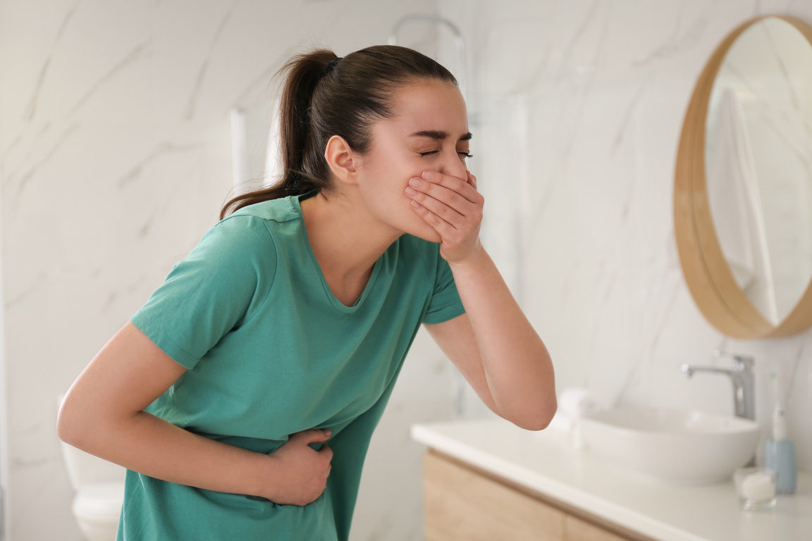 Young Woman Suffering from Nausea in Bathroom. Food Poisoning